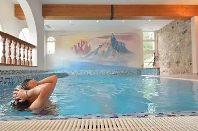 a person swimming in a swimming pool in a building at Hotel Rio Bianco in Panchia