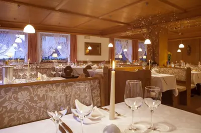 a dining room with tables with wine glasses at Hotel Ingram in Selva di Val Gardena