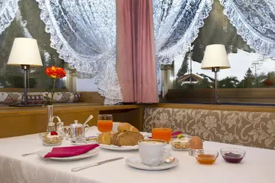 a table with a plate of food and drinks on it at Hotel Ingram in Selva di Val Gardena