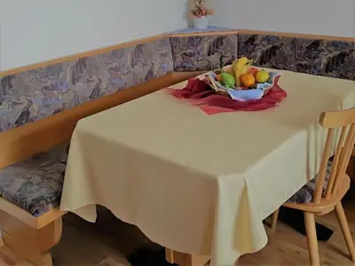 a white table with a bowl of fruit on it at Zimmer - Hinterwalderhof in Mühlbach