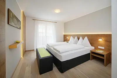 a hotel room with a bed and a table at Hotel Garni Paler in Tirolo