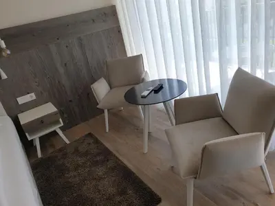 a table and chairs in a room with a window at Hotel Jasmin in Merano