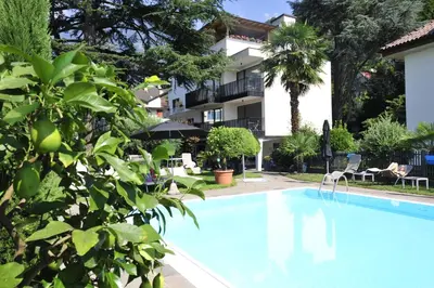 a swimming pool in front of a building at Hotel Jasmin in Merano