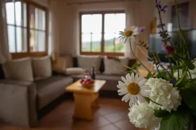 a living room with a couch and a table with flowers at Schwarzplatterhof in Merano