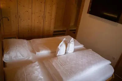 a bedroom with two beds with white sheets at Schwarzplatterhof in Merano