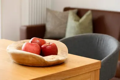 two apples in a wooden bowl on a table at Landhaus Weger in Merano