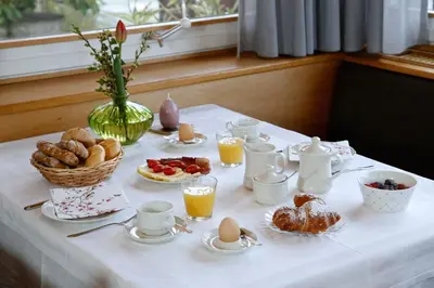 a table with breakfast foods and coffee on it at Landhaus Weger in Merano