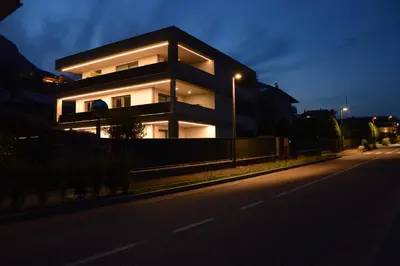 a building on the side of a street at night at Family Apartment Julia in Termeno