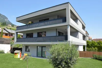 a white house with a yard at Family Apartment Julia in Termeno