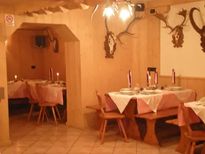 a dining room with tables and chairs with lit candles at Hotel La Molinella in Soraga
