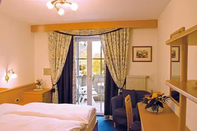 a hotel room with a bed and a window at Hotel Dolomitenblick in Collalbo