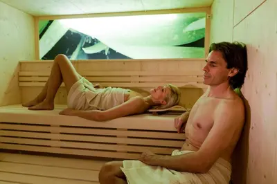 a man and a woman sitting in a sauna at Brunnerhof Klausen-Chiusa in Chiusa