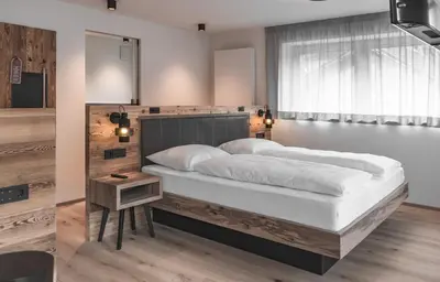 a bedroom with a large bed and a window at Brunnerhof Klausen-Chiusa in Chiusa