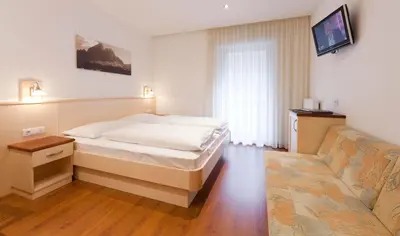 a bedroom with a bed and a couch at Brunnerhof Klausen-Chiusa in Chiusa