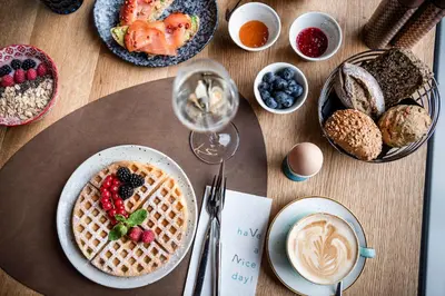 a table topped with plates of waffles and breakfast foods at Viel Nois Guest House in Funes