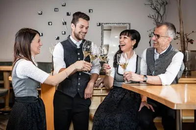a group of people standing around a table drinking wine at Viel Nois Guest House in Funes