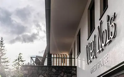 a building with a sign on the side of it at Viel Nois Guest House in Funes