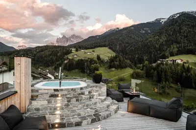 a patio with a hot tub on top of a mountain at Viel Nois Guest House in Funes