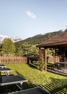 a backyard with picnic tables and a gazebo at Raschötzhof in Funes