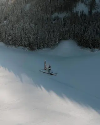 a small house in the middle of a snow covered lake at Raschötzhof in Funes