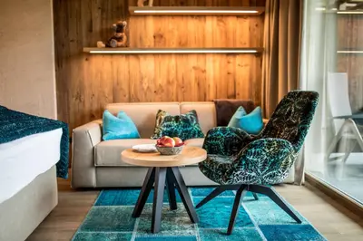 a living room with a couch and a table and chairs at Andreus Resorts in San Leonardo in Passiria