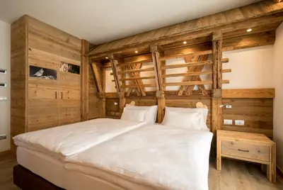 a bedroom with a large bed with wooden walls at Agriturismo Malga Piè in Soraga