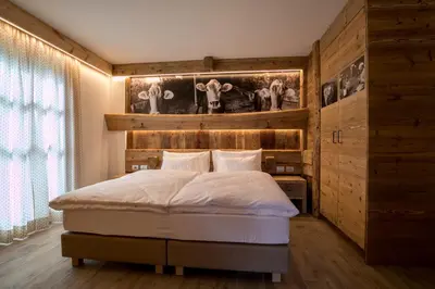 a bedroom with a bed with a wooden wall at Agriturismo Malga Piè in Soraga