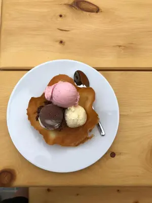 a white plate with ice cream on a table at Agriturismo Malga Piè in Soraga