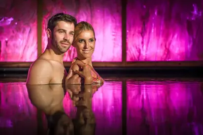 a man and a woman standing in the water at Hotel Sonnenalm in Saltusio