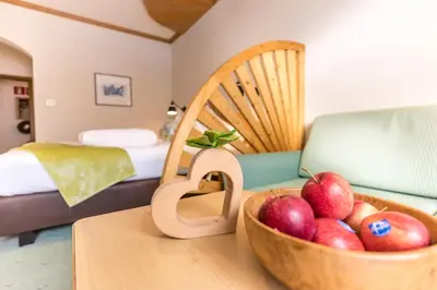 a bowl of apples on a table in a room at Hotel Sonnenalm in Saltusio