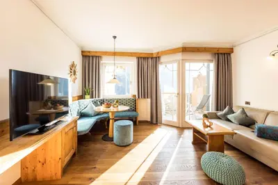 a living room with a couch and a tv at Hotel Sonnenalm in Saltusio