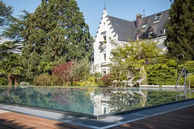 a house with a swimming pool in front of a building at Hotel Sonnenhof in Merano