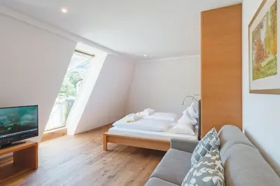 a living room with a couch and a tv at Hotel Sonnenhof in Merano