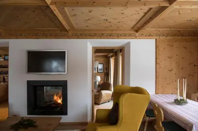 a bedroom with a blue couch next to a bed at Mountain Home Villa Anna in Selva di Val Gardena