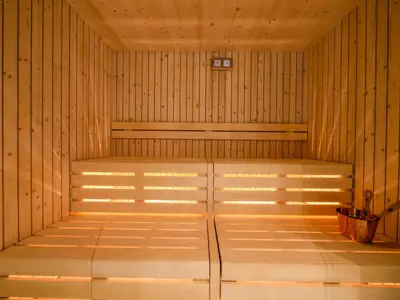 a sauna with wooden walls and a glass door at Mountain Home Villa Anna in Selva di Val Gardena