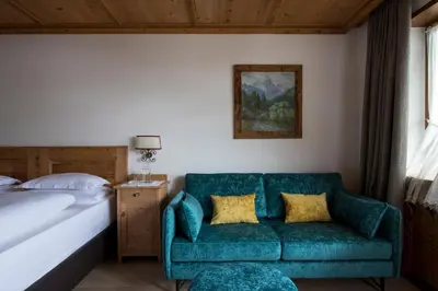 a living room with a chair and a staircase at Mountain Home Villa Anna in Selva di Val Gardena
