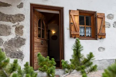 a wooden bench sitting in front of a building at Romantic Loft Sottoguda in Sottoguda