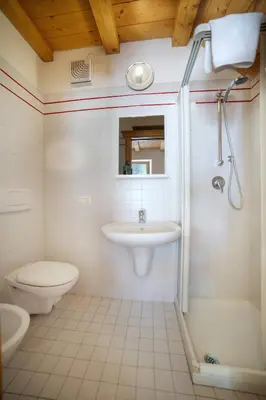 a white bathroom with a sink and a toilet at Romantic Loft Sottoguda in Sottoguda