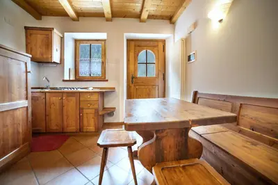 a kitchen with wooden cabinets and a sink at Romantic Loft Sottoguda in Sottoguda
