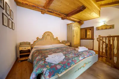 a bed in a room with two nightstands and a bed with aintendent at Romantic Loft Sottoguda in Sottoguda