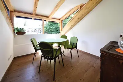 a dining room with a table and green chairs at Castel Campan in Bressanone
