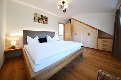 a bedroom with a large bed with white sheets at Castel Campan in Bressanone
