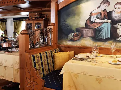 a dining room with a table and a painting at Leading Relax Hotel Maria in Moena
