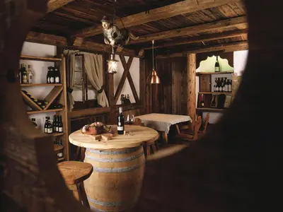 a room with a table and chairs and a room with a barrel at Leading Relax Hotel Maria in Moena
