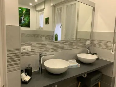 a bathroom with two sinks and a mirror at CEJM Apartments Merano in Merano