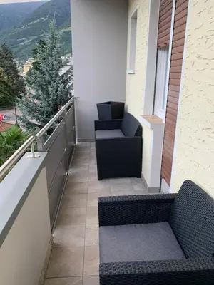 a balcony with two chairs and a view of a mountain at CEJM Apartments Merano in Merano