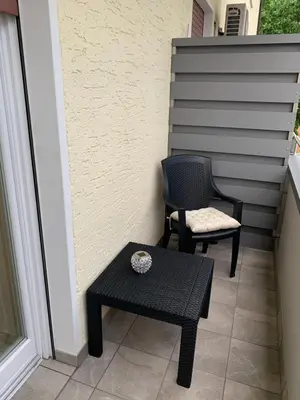 a patio with two chairs and a table and a stool at CEJM Apartments Merano in Merano