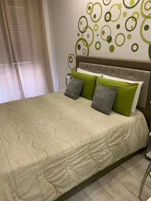 a bed with green pillows on it in a bedroom at CEJM Apartments Merano in Merano