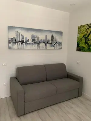 a couch in a room with a picture of a city at CEJM Apartments Merano in Merano