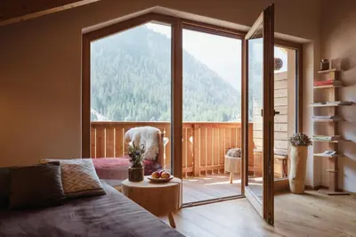 a bedroom with a bed and a couch and a chair at Berghotel Sanví in San Martino in Badia